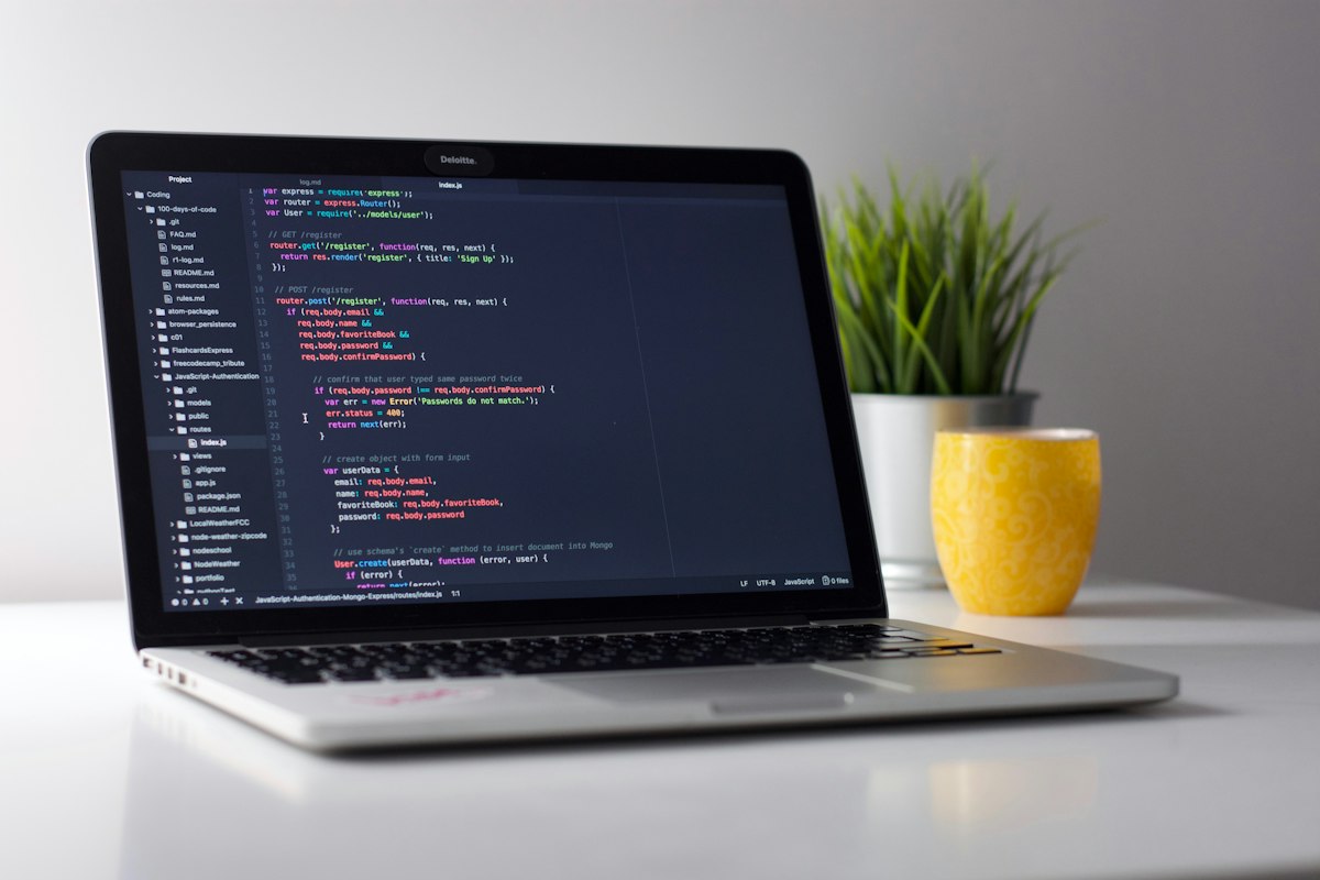 Developer coding on laptop with modern workspace